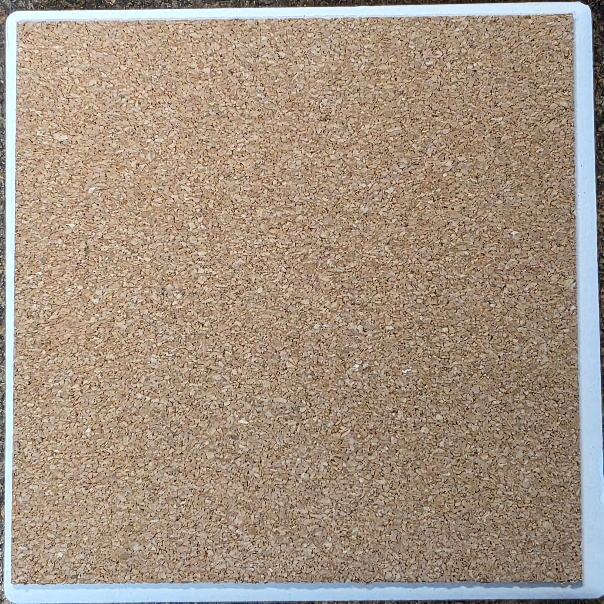 Square tile with a textured beige surface