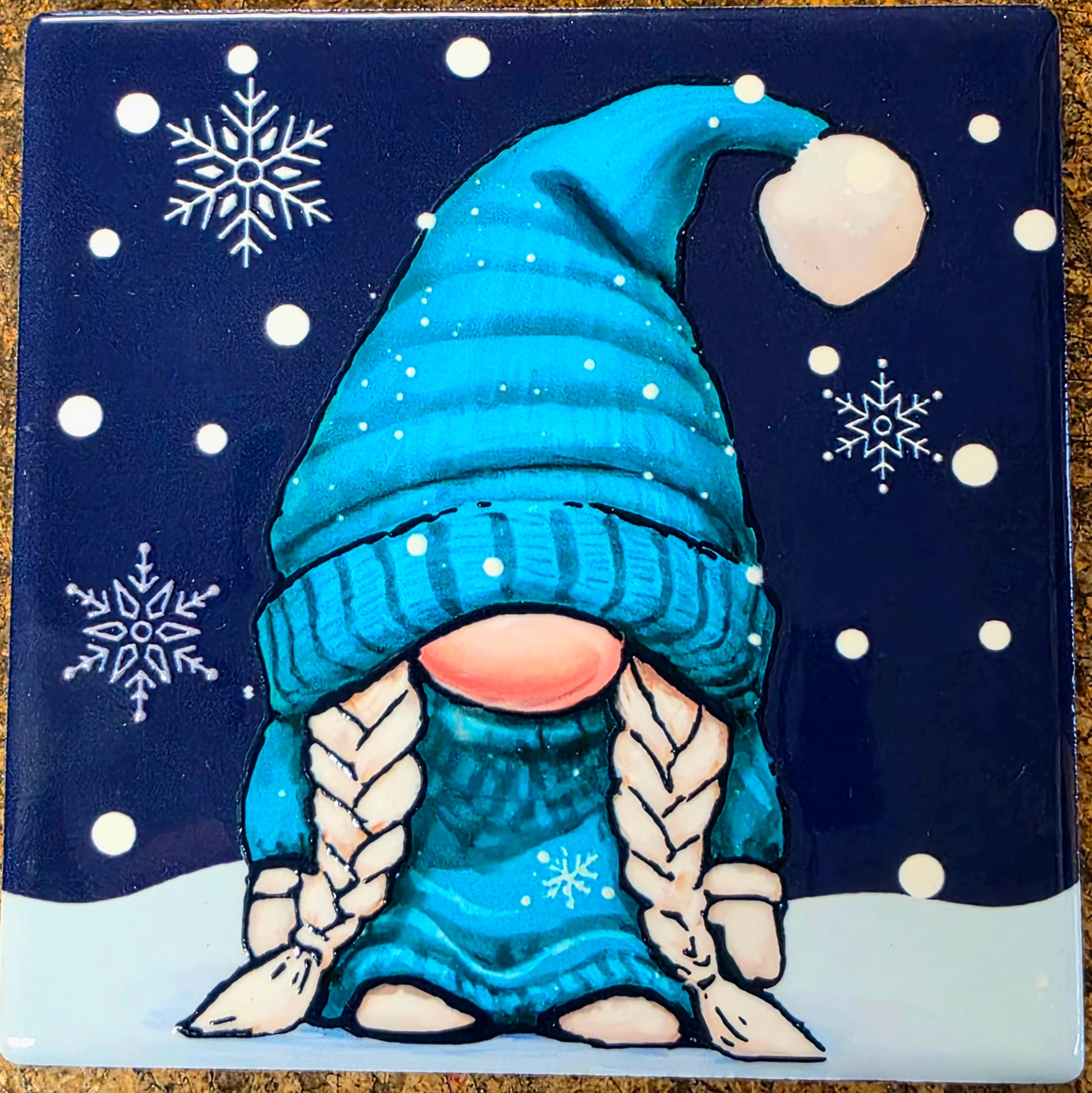Gnome with a blue hat and scarf on a snowy night background
