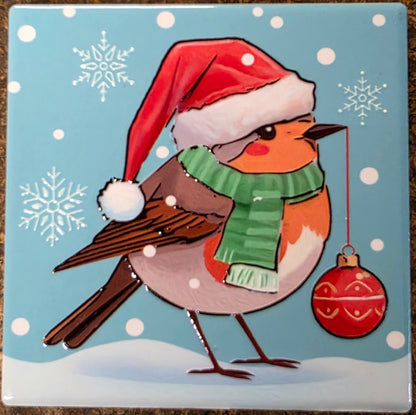 Illustration of a bird wearing a Santa hat and green scarf with snowflakes and a red ornament on a blue background.
