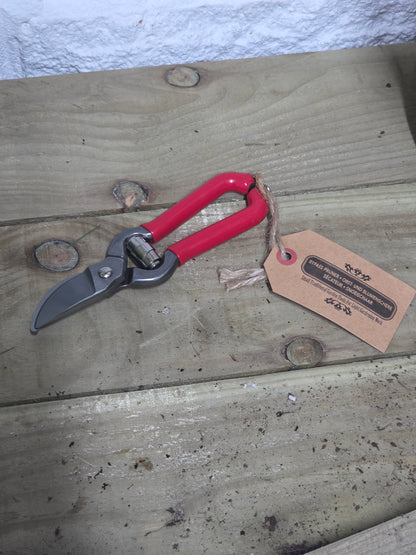 Red bypass pruners on a wooden table