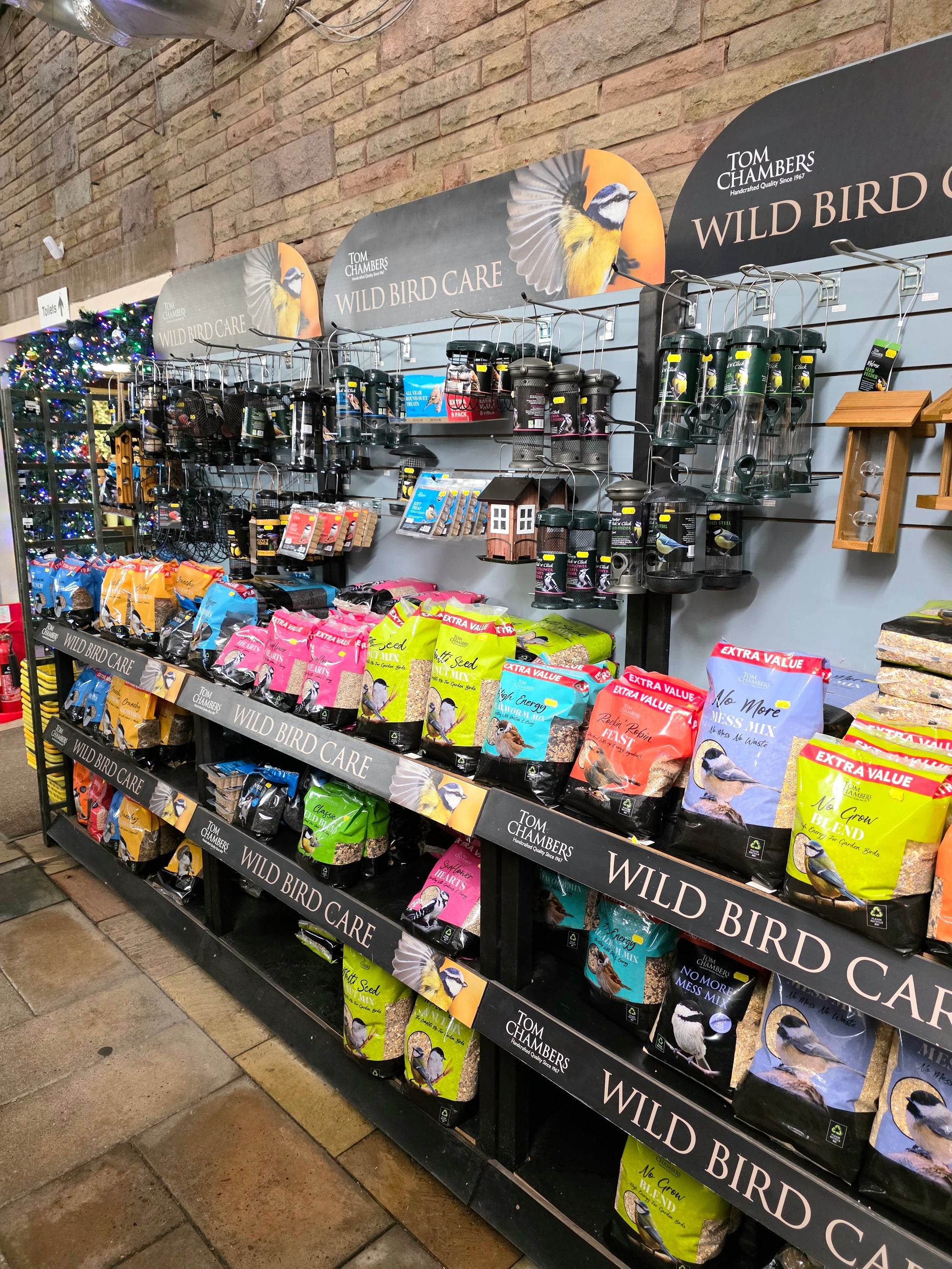 Display of wild bird care products in a store with 'Tom Chambers' branding.