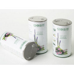Two cans of Oasis floral foam with a floral arrangement on a white background