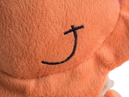 Close-up of an orange plush toy with a black smiley face design on a white background
