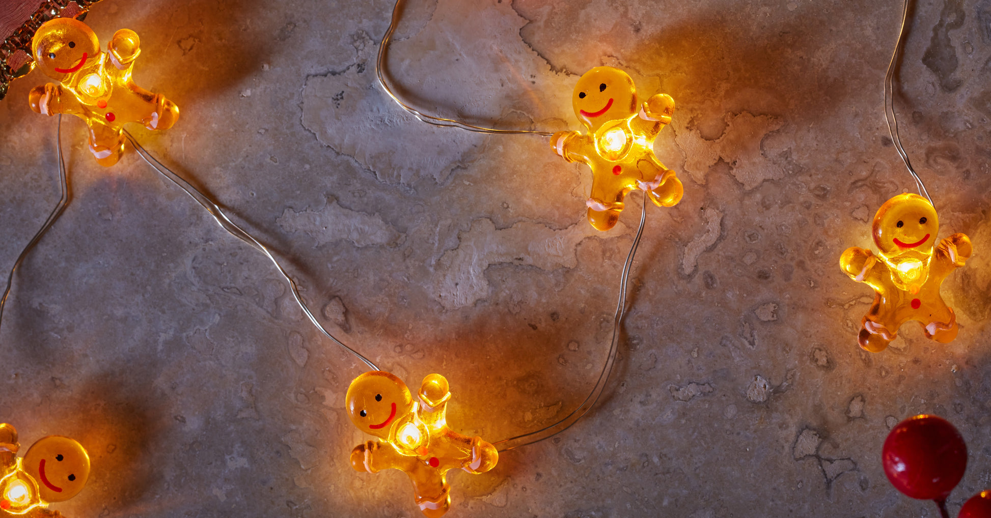 String of glowing gingerbread man lights on a textured surface