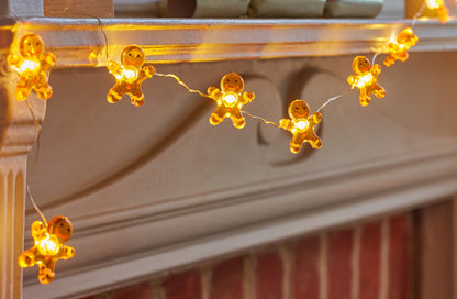 String of gingerbread man lights on a mantelpiece.