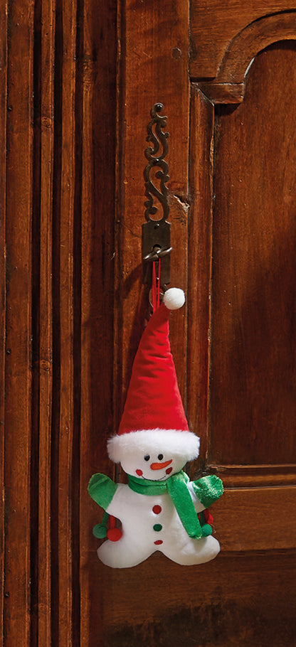 Snowman keychain with a red hat and green scarf hanging on a wooden door.