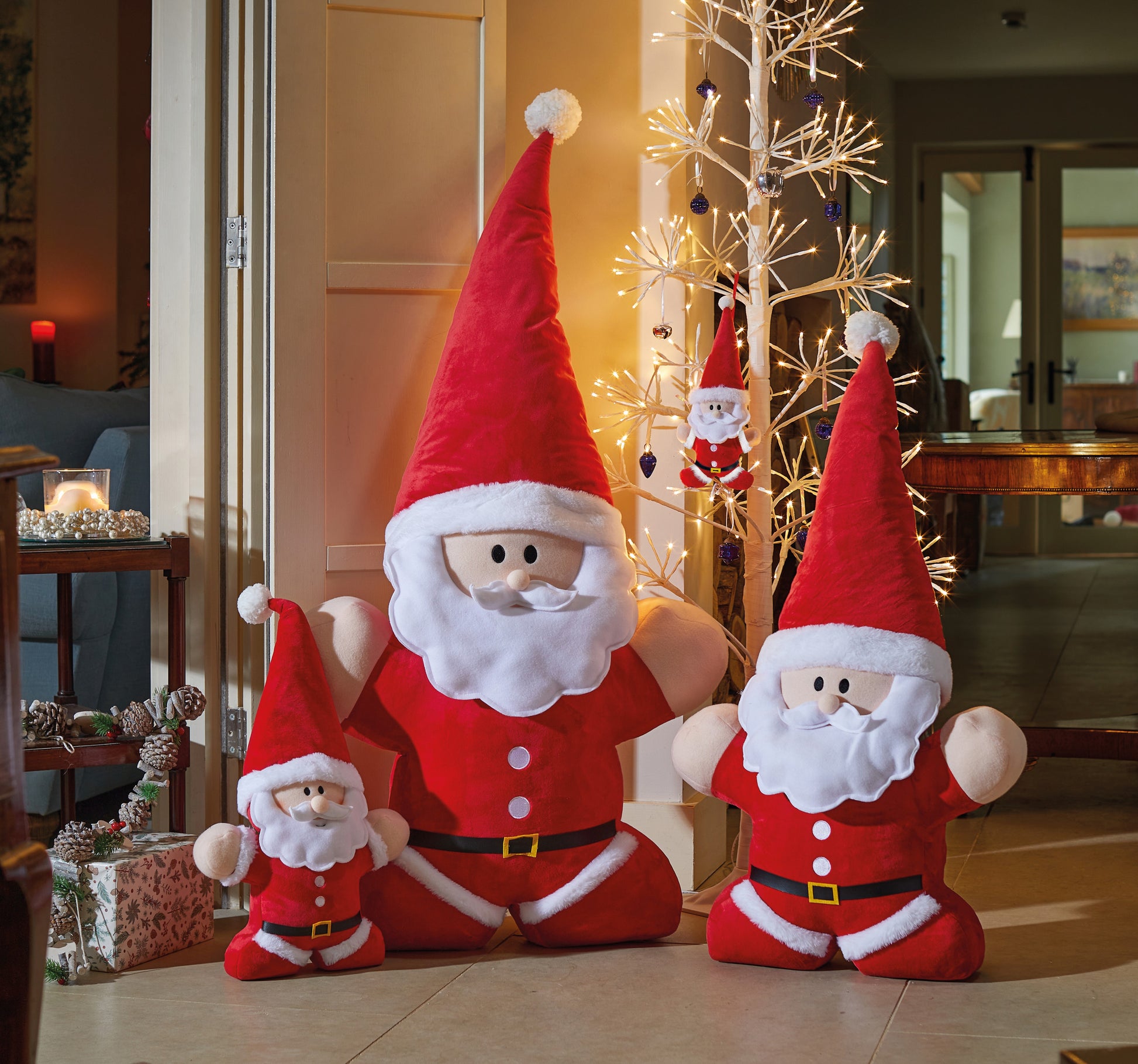 Set of Santa Claus figurines in a living room with Christmas decorations.