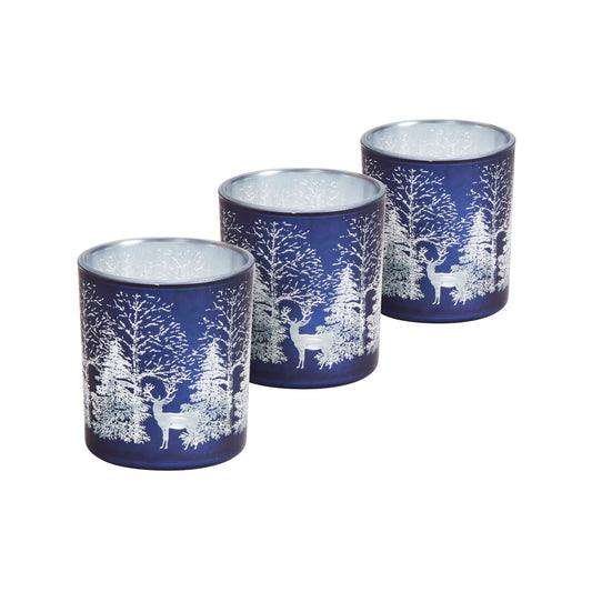 Set of three blue candle holders with white deer and forest design on a white background
