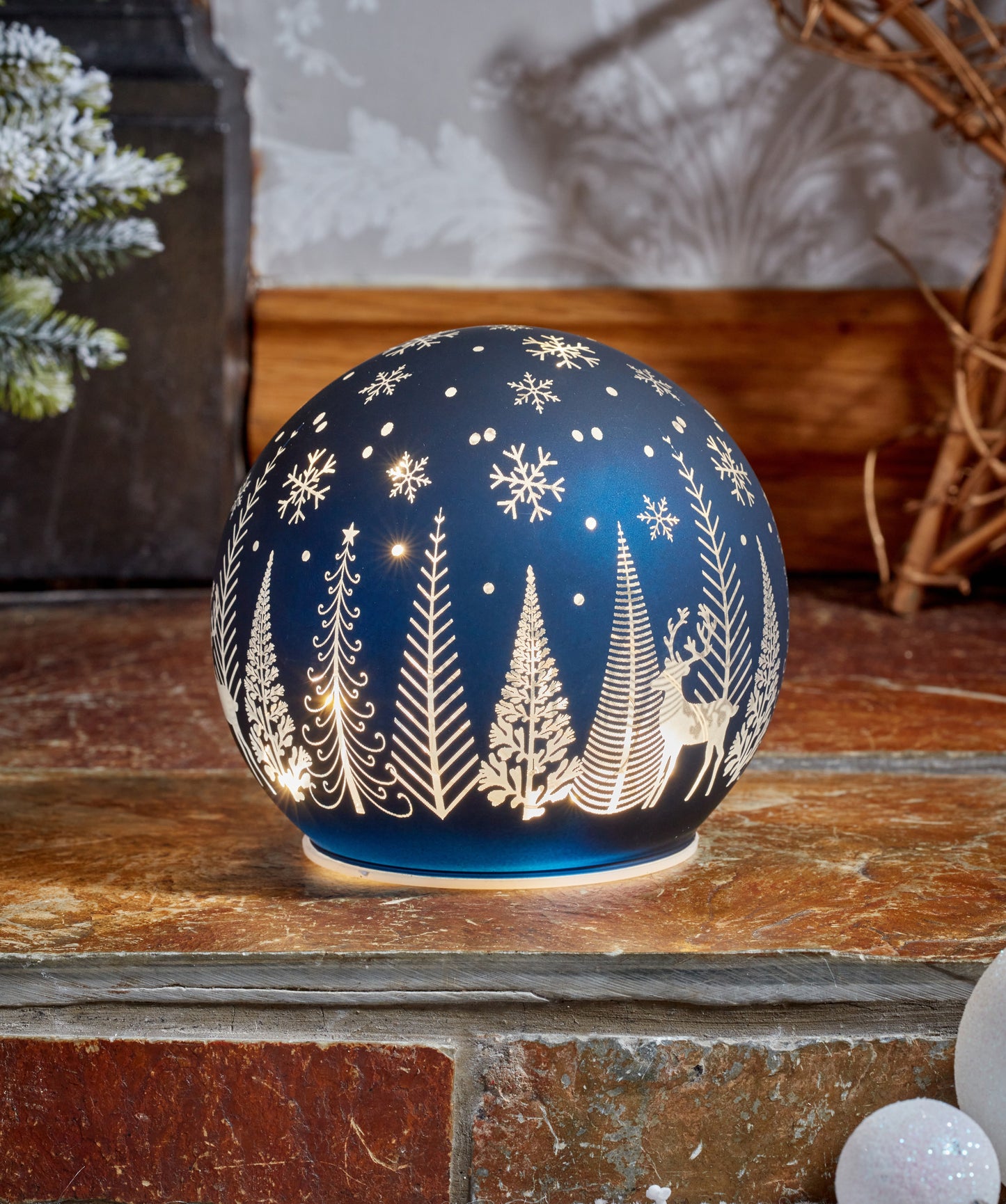 Decorative night light with winter scene design on a wooden surface