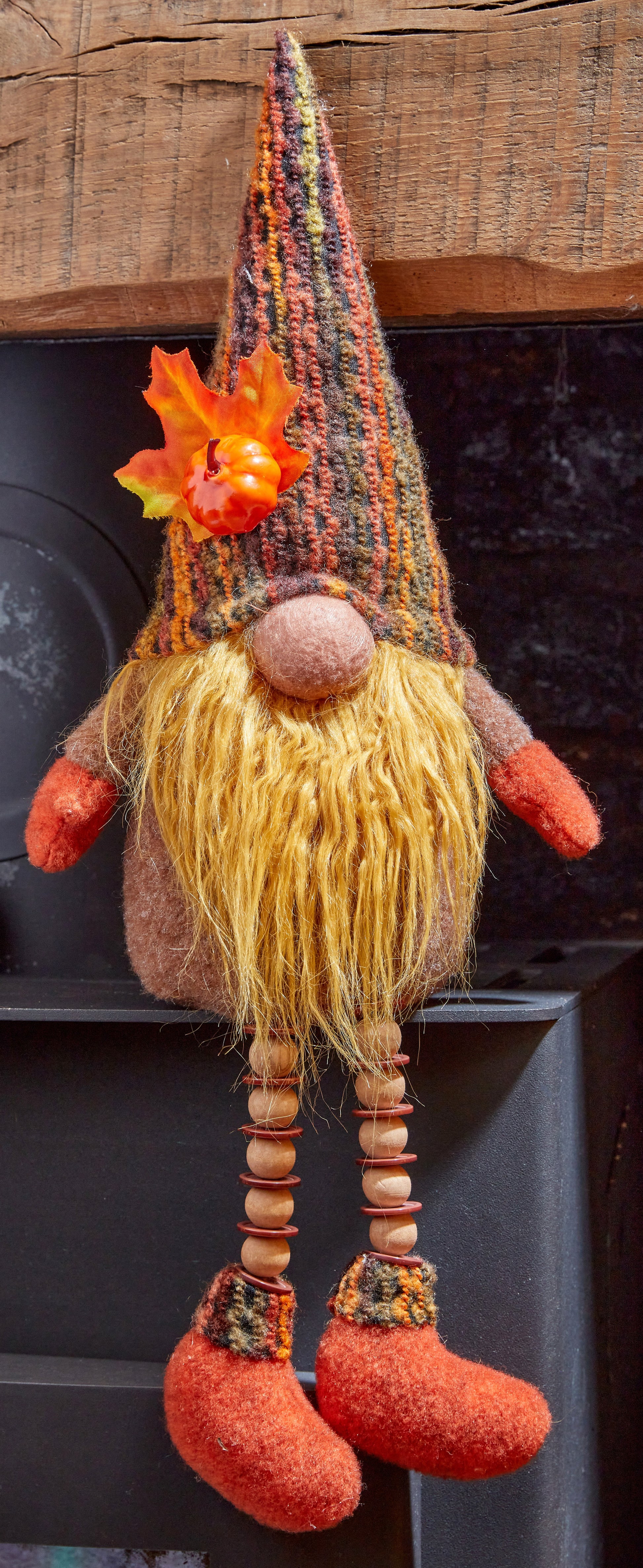 Decorative gnome with a colorful hat and red shoes on a dark background