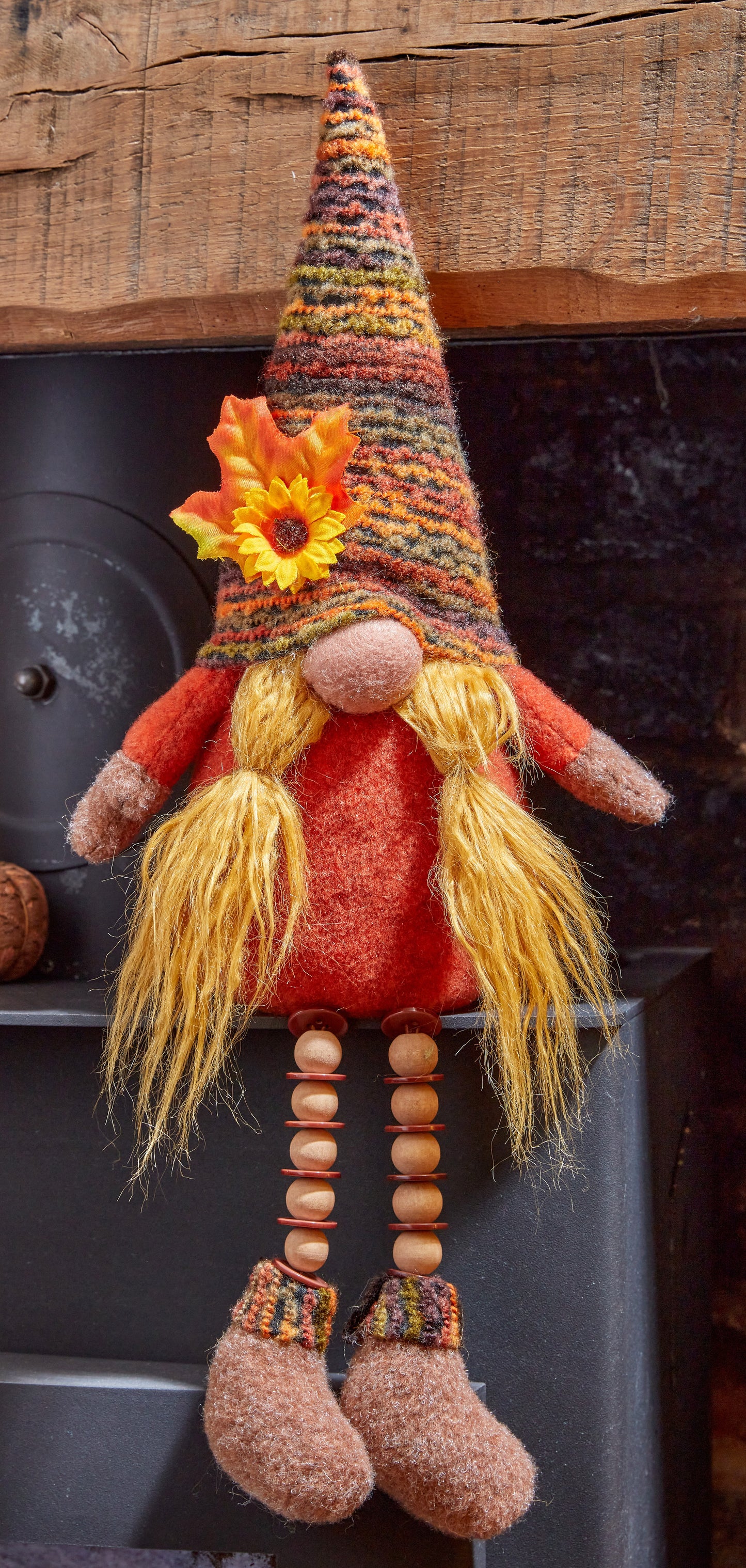 Decorative gnome with a colorful hat and long yellow hair on a wooden surface