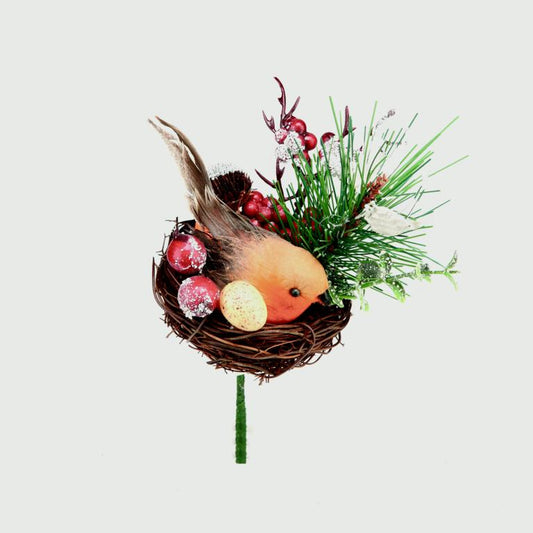 Decorative arrangement with a bird in a nest, berries, and greenery on a white background
