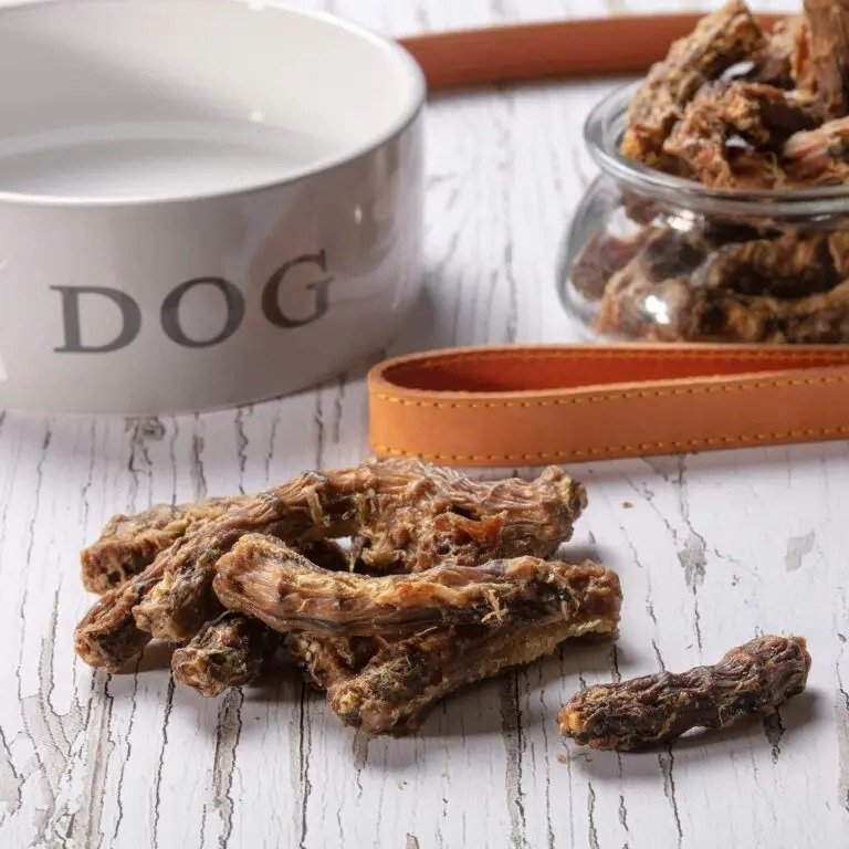 Hollings 100% Natural Chicken Necks on a table next to a white dog bowl and a dog lead