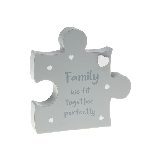 Gray puzzle piece-shaped decorative item with 'Family we fit together perfectly' text on a white background