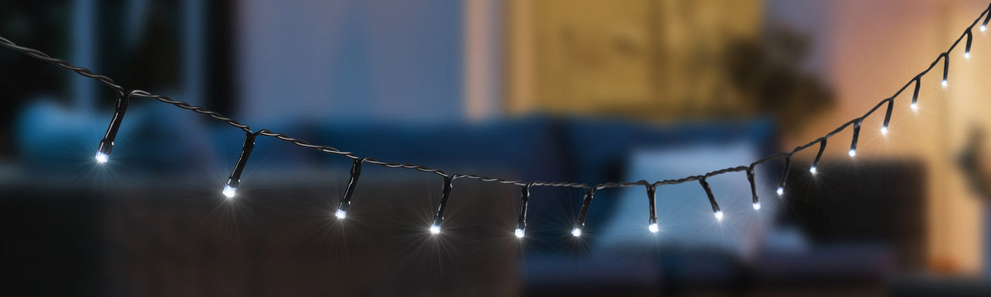 String of lights draped over a sofa with a blurred indoor background