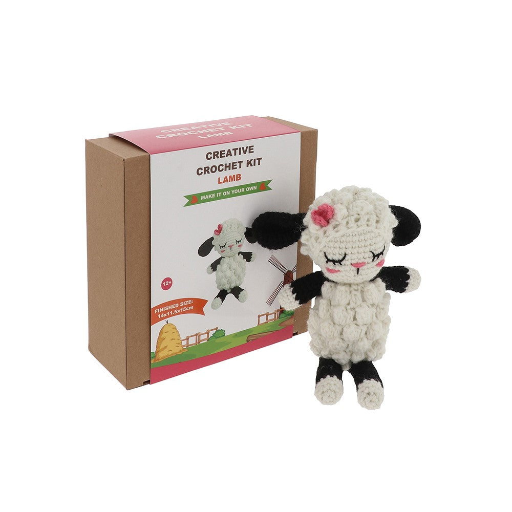 Crocheted lamb toy in front of a 'Creative Crochet Kit' box on a white background