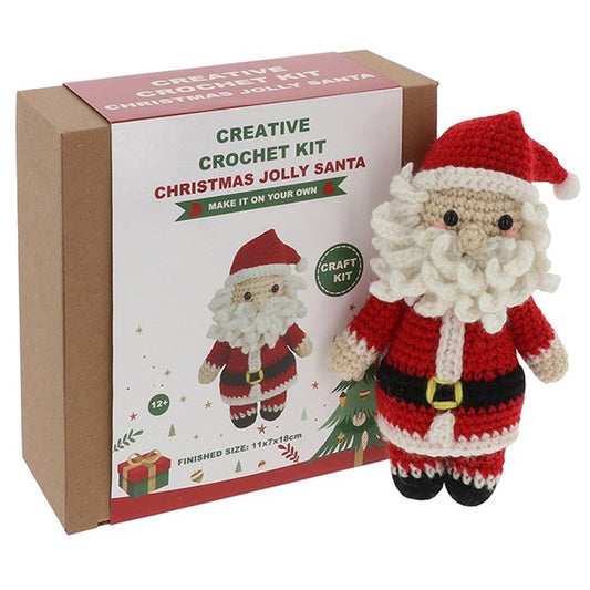 Crocheted Santa Claus figure next to a Creative Crochet Kit box on a white background