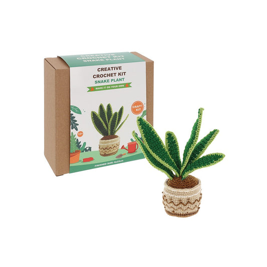 Crocheted snake plant next to its packaging on a white background