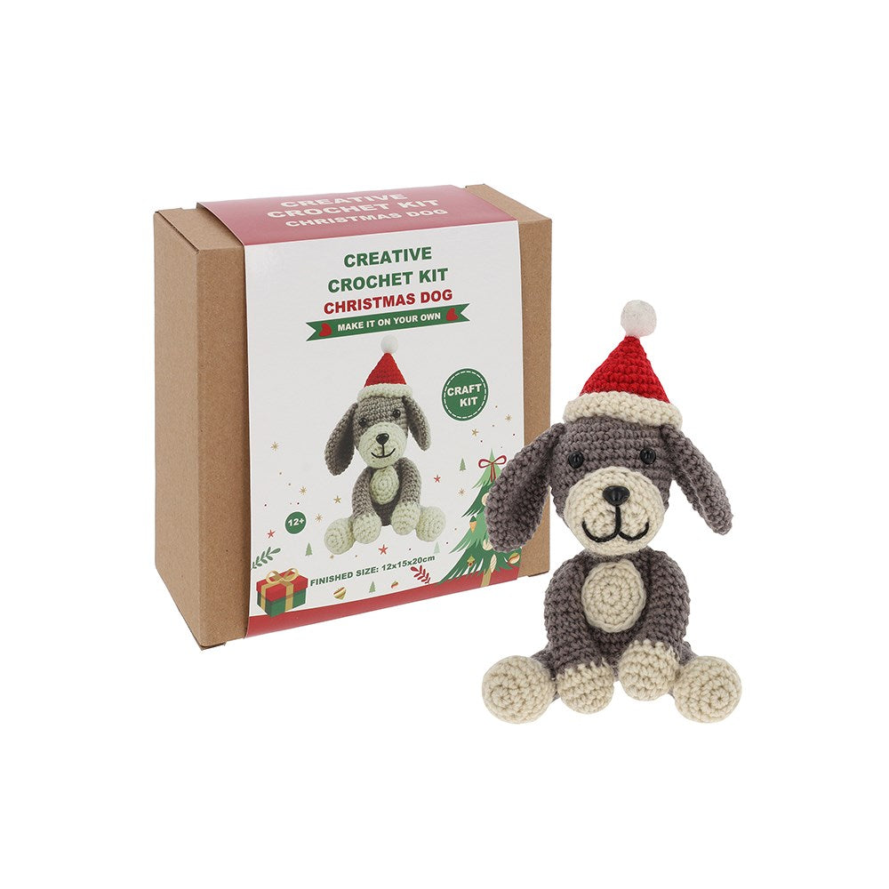 Crocheted Christmas dog toy with a Santa hat next to its packaging on a white background