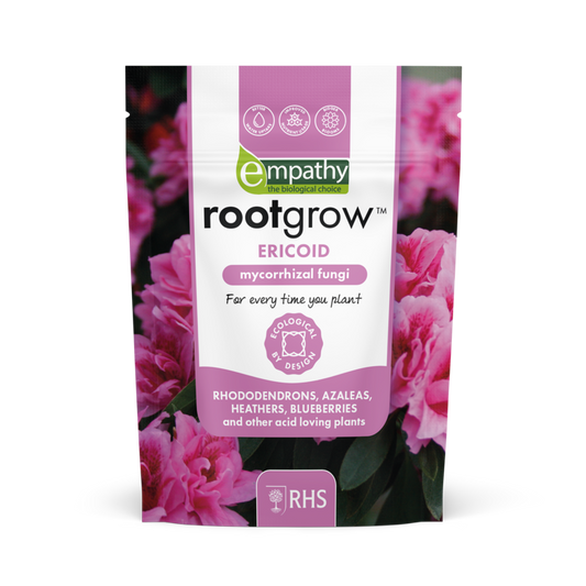 Rootgrow mycorrhizal fungi package with pink flowers in the background