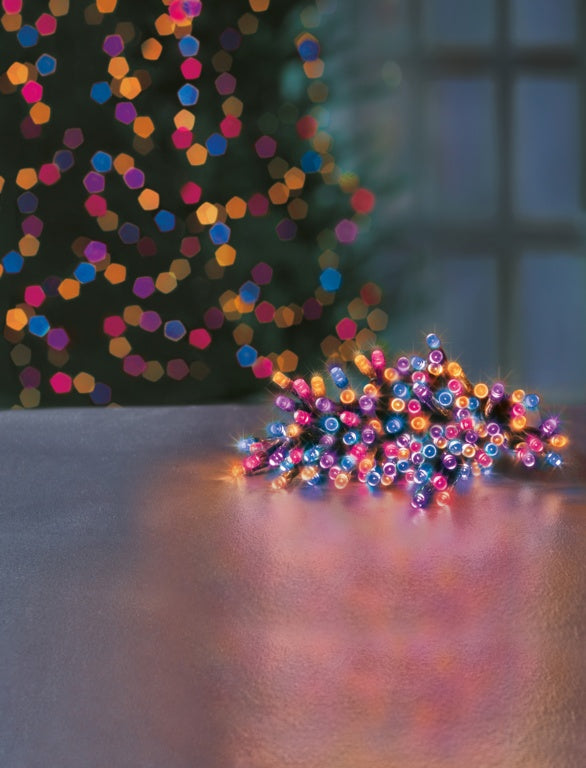 Multicolored string lights on a reflective surface with a blurred background