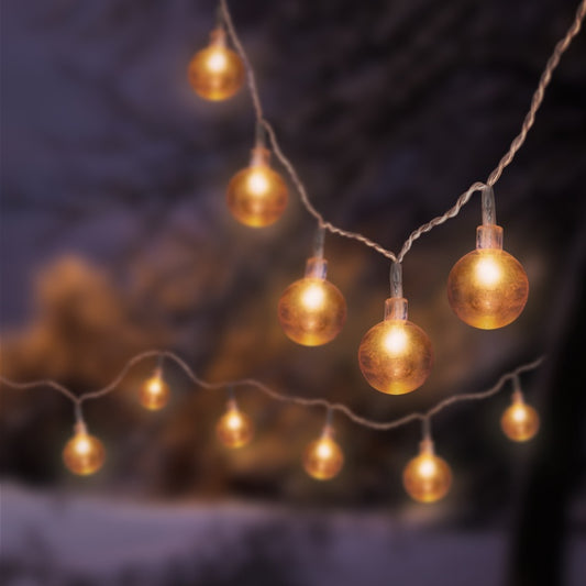 String of glowing gold lights against a blurred natural background