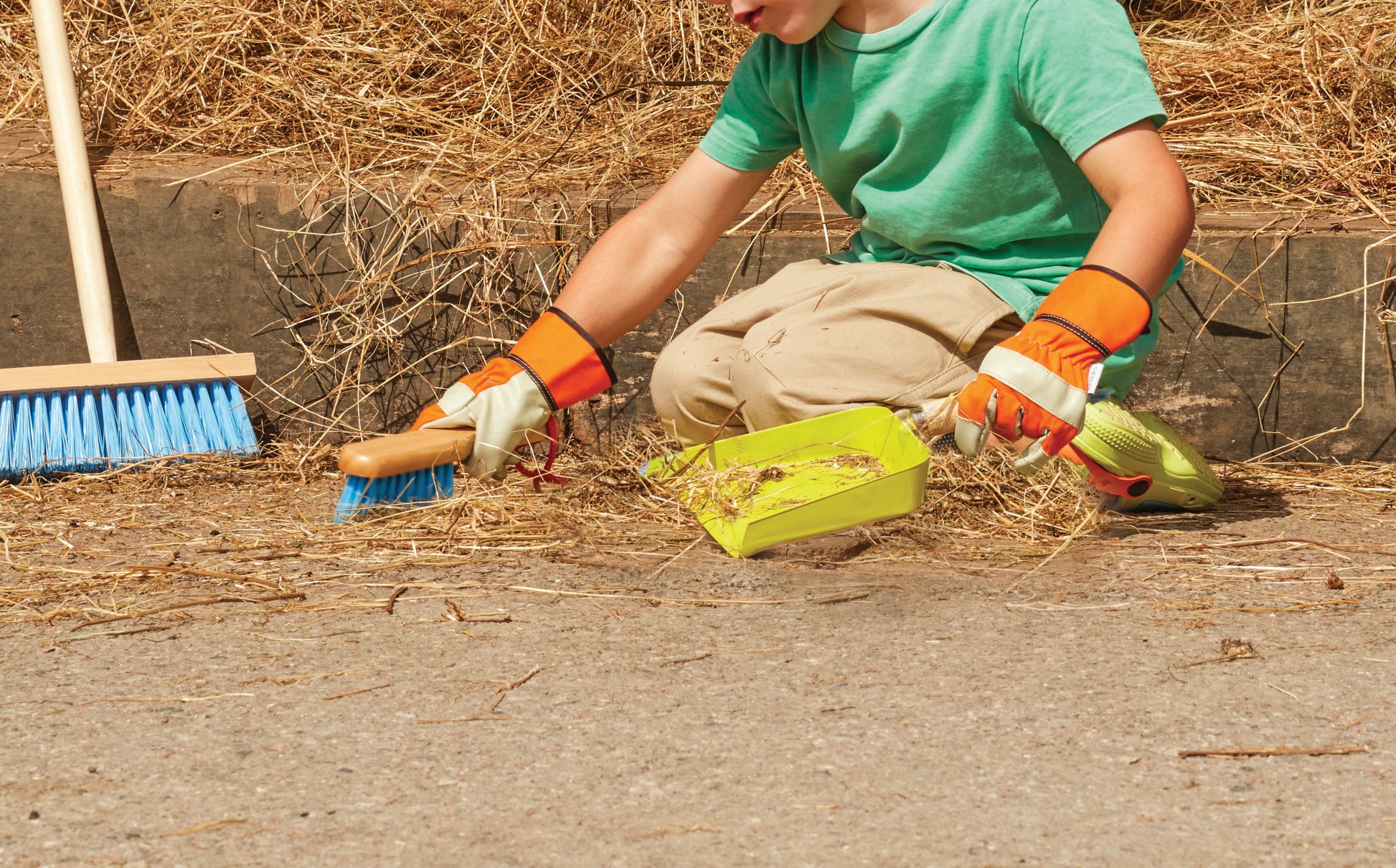 Person cleaning up with tools on a concrete surface