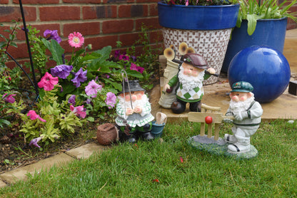 Gnome figurines in a garden setting with flowers and potted plants.
