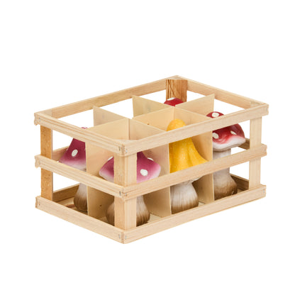 Wooden crate with toy mushrooms inside on a white background