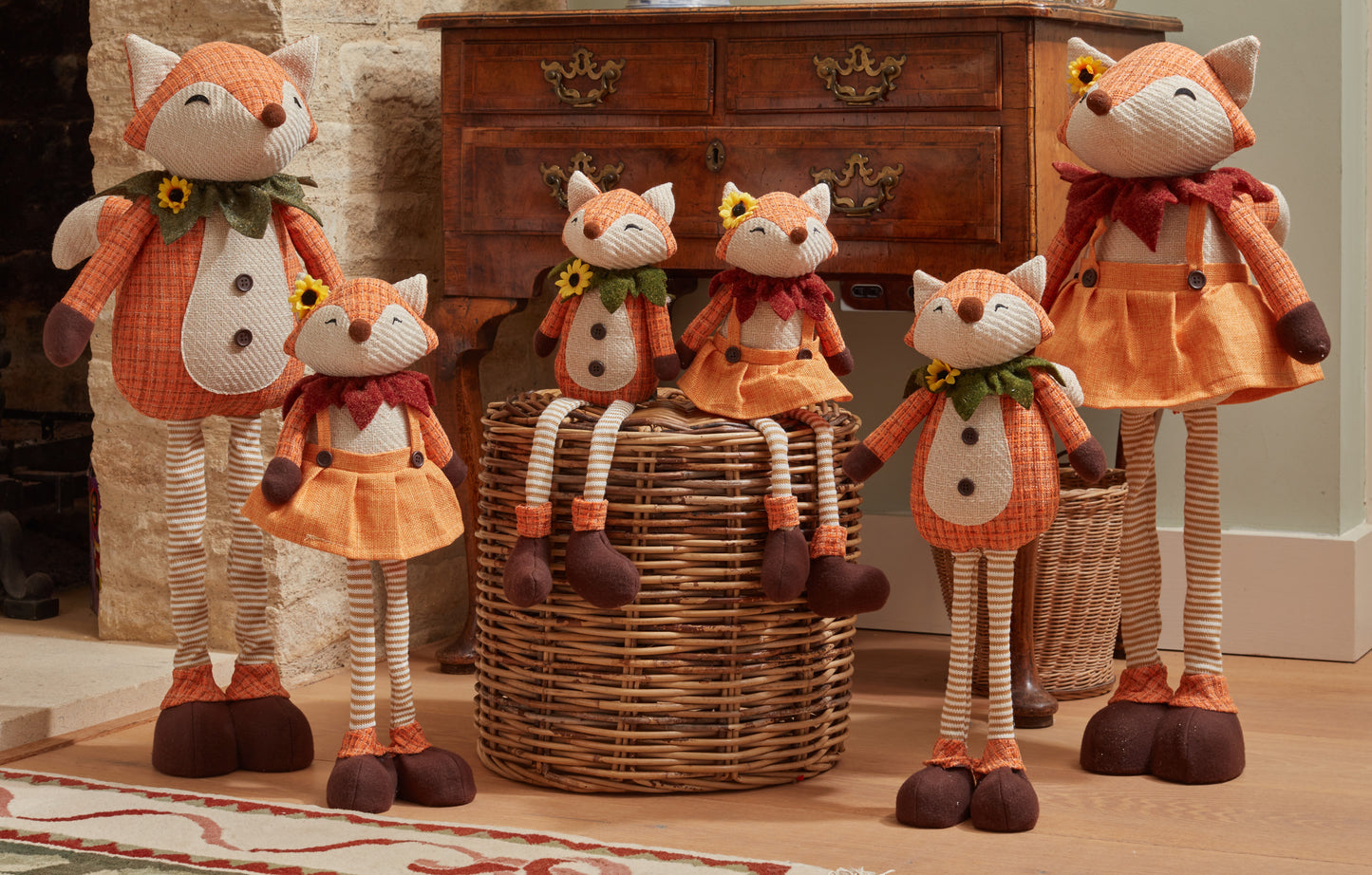 Six fox-shaped decorative items in front of a wooden dresser.