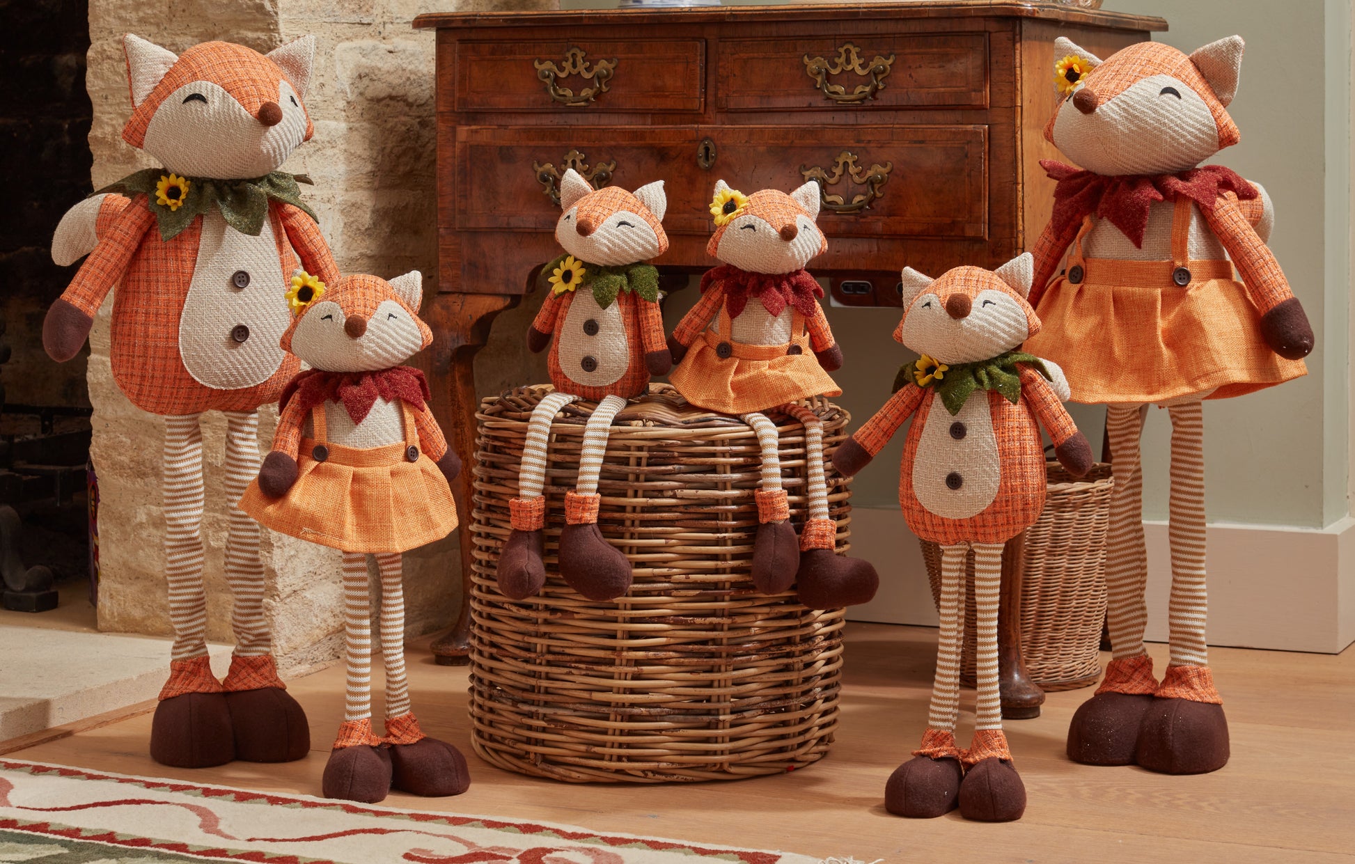 Six fox-shaped decorative items in front of a wooden dresser.