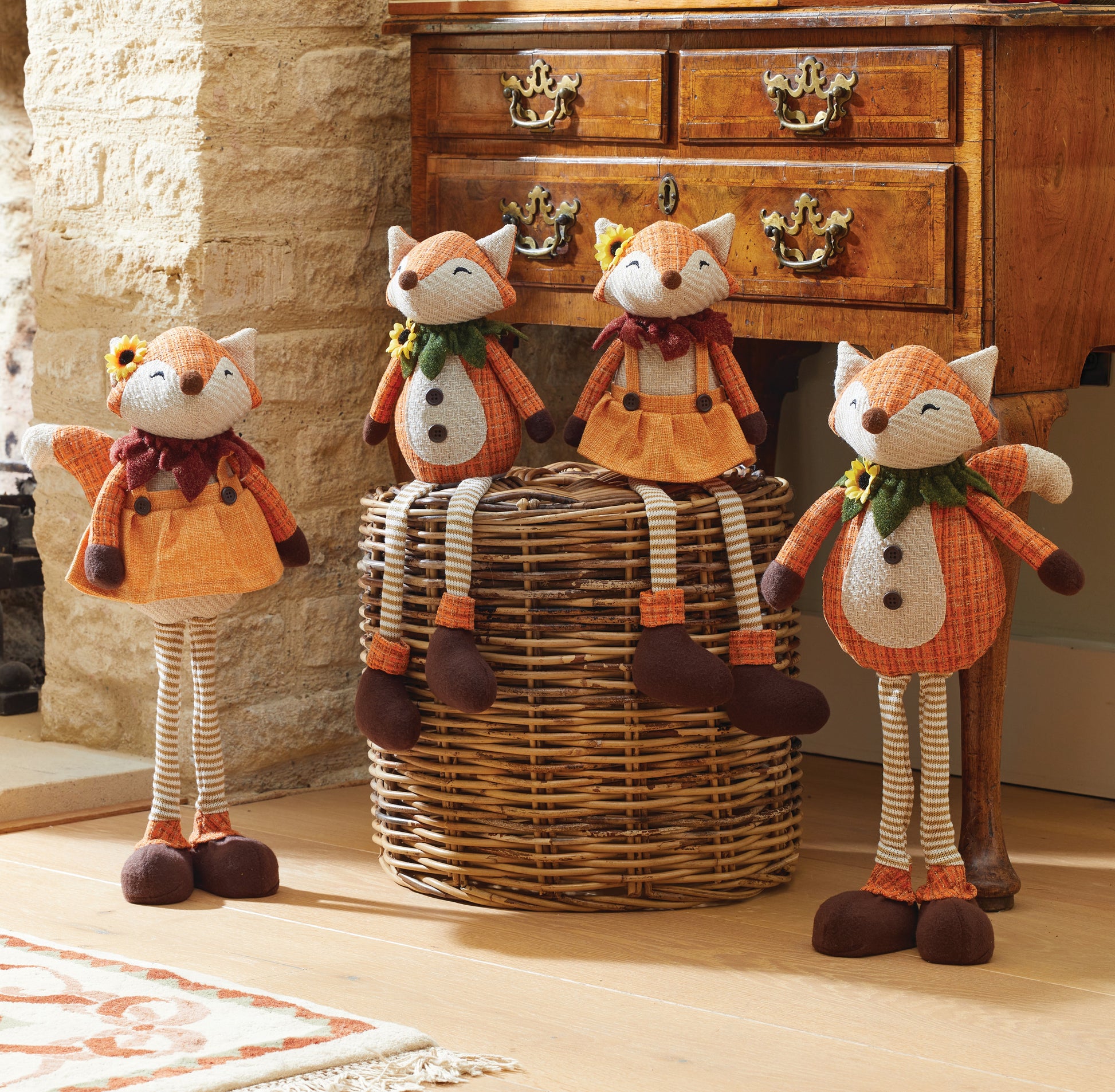 Four fox-shaped decorative items in front of a wooden dresser.