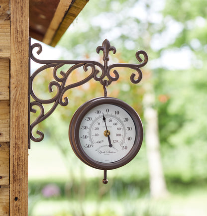 Decorative outdoor thermometer with decorative bracket on a wooden post.