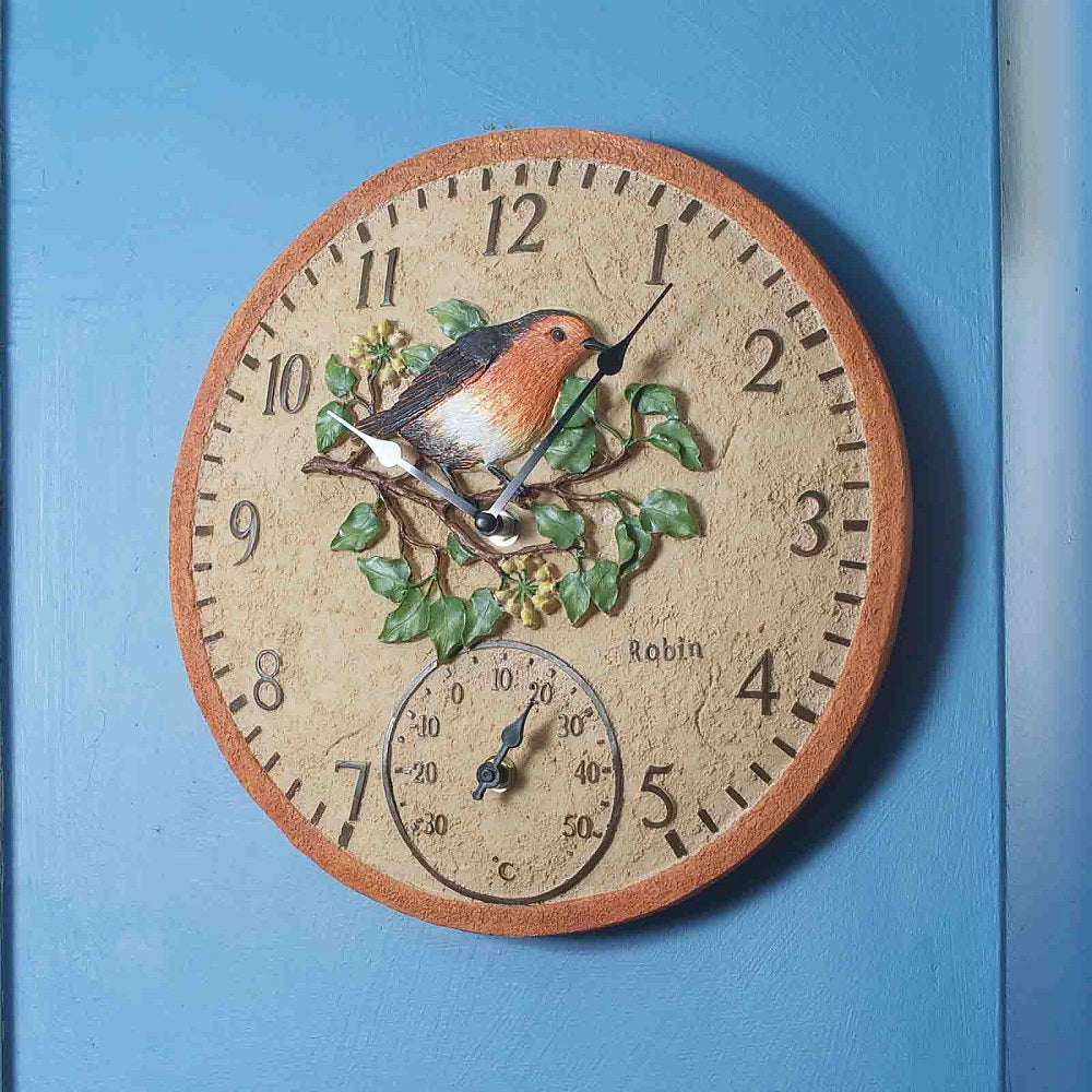 Decorative wall clock with a bird design on a blue background