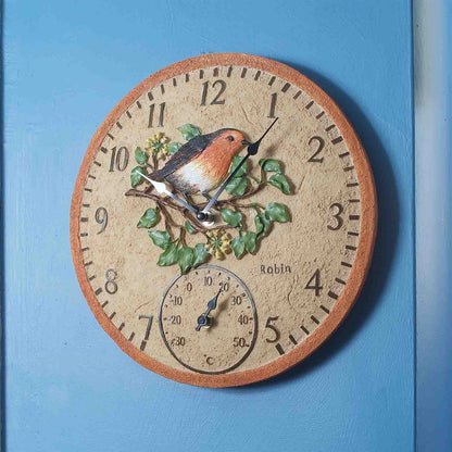 Decorative wall clock with a bird design on a blue background
