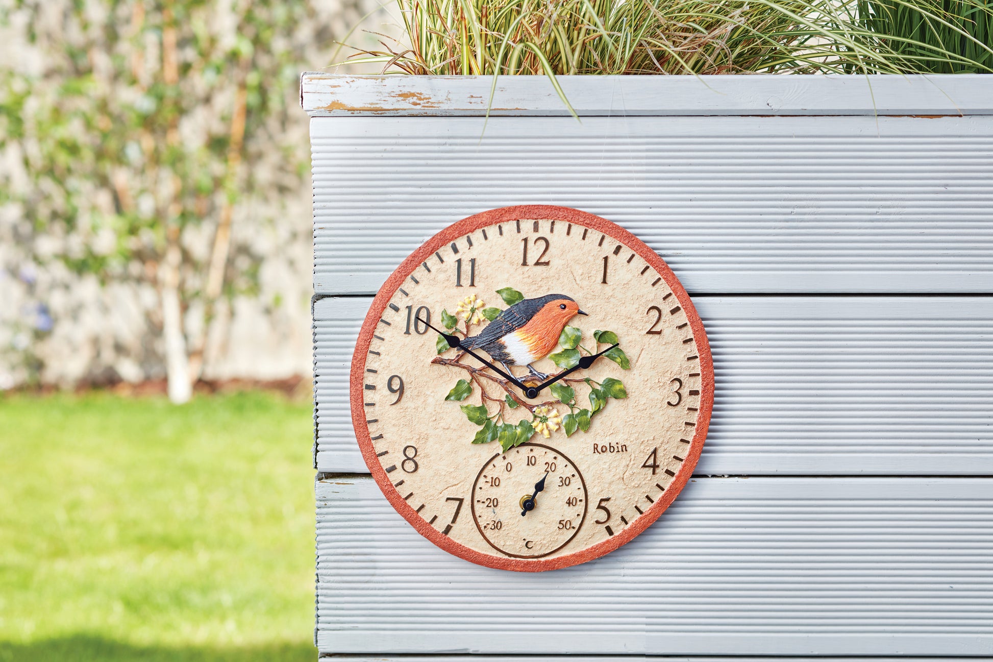 Decorative clock with a bird design on a wooden surface outdoors