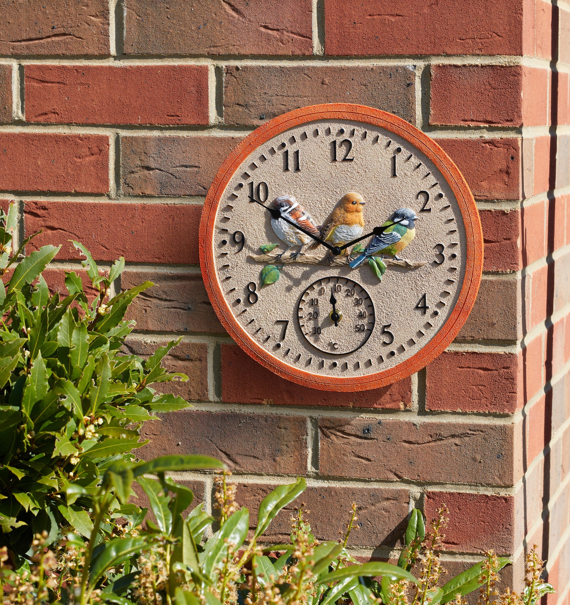 Decorative wall clock with bird design on a brick wall