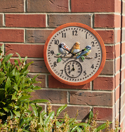 Decorative wall clock with bird design on a brick wall