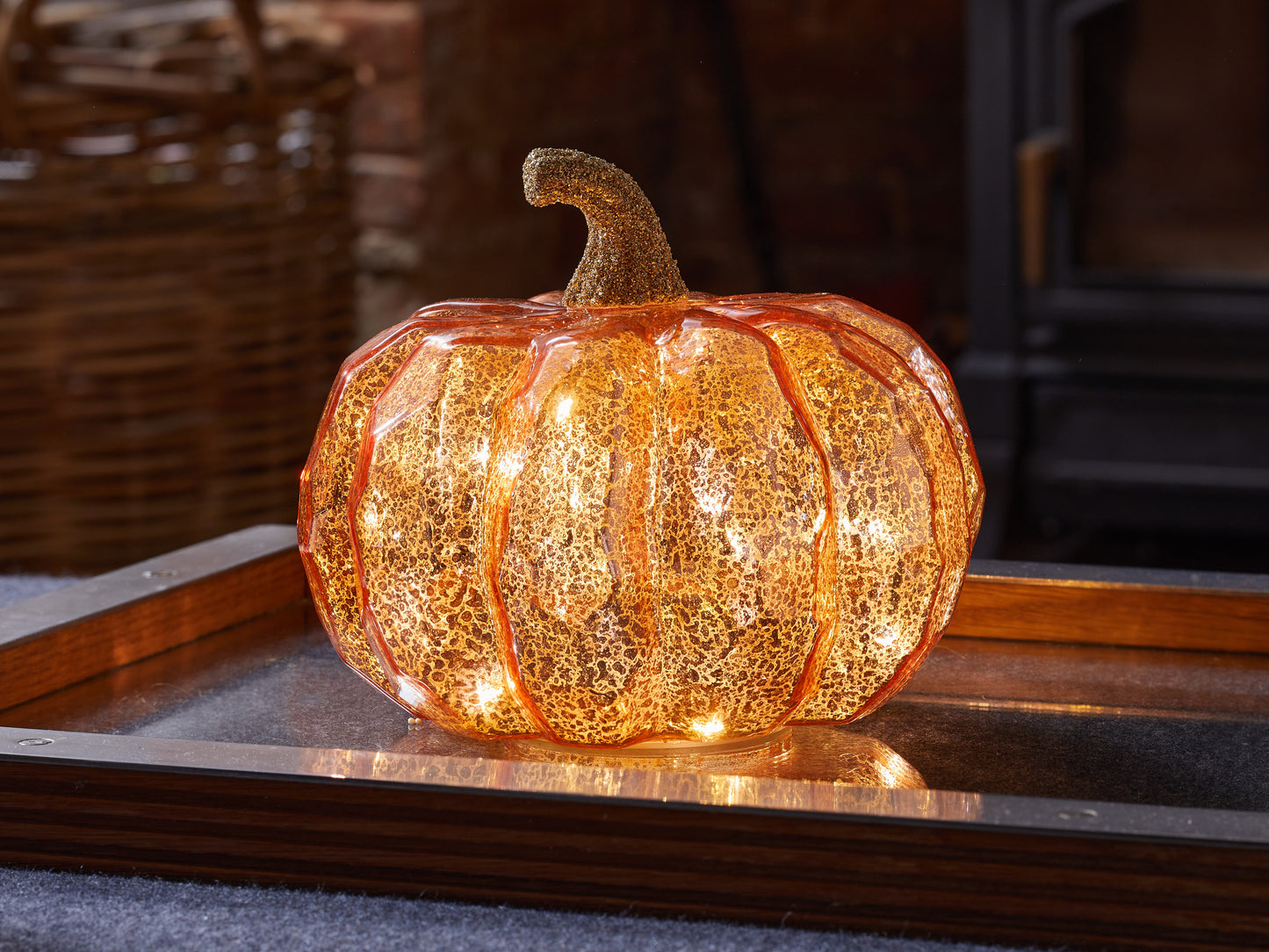 Decorative pumpkin with string lights on a wooden surface