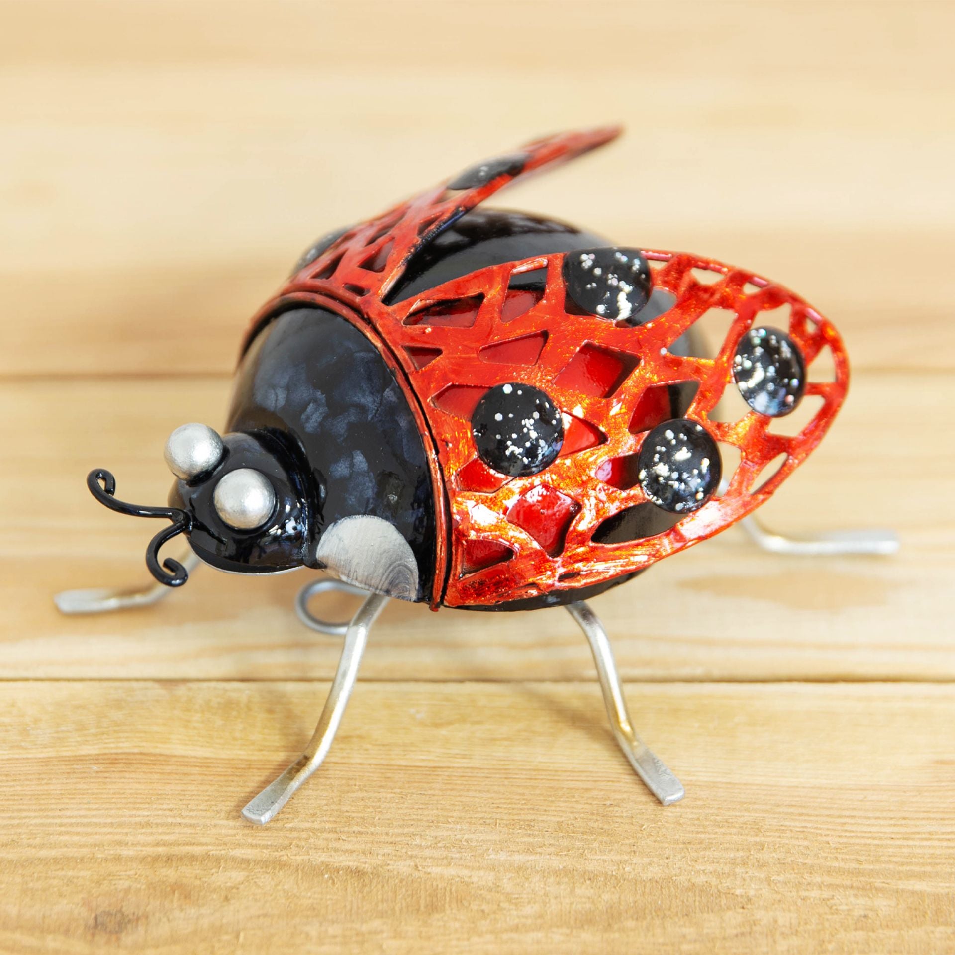 Decorative ladybug sculpture on a wooden surface