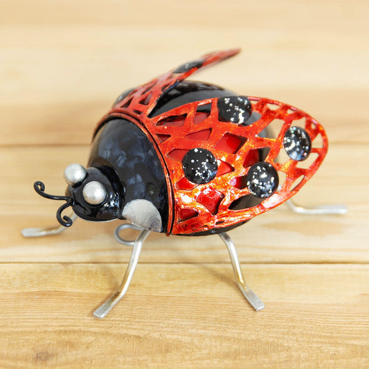 Decorative ladybug sculpture on a wooden surface