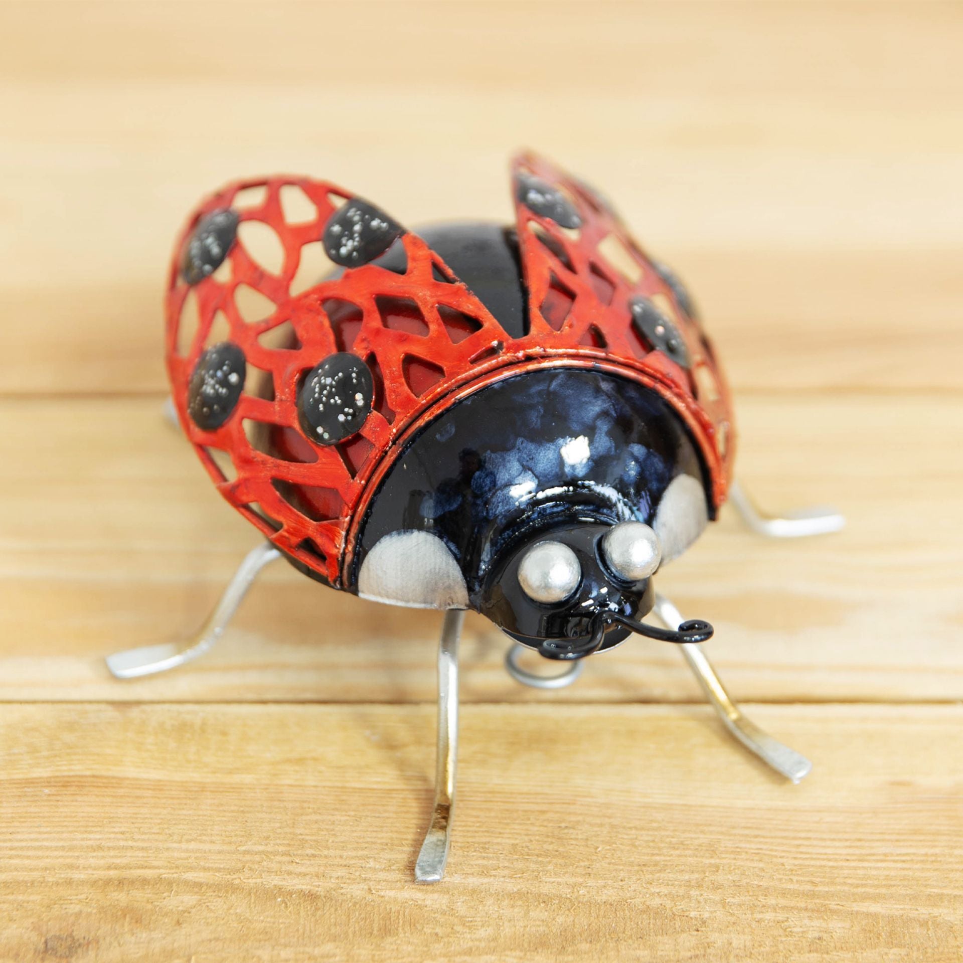 Decorative ladybug figurine on a wooden surface