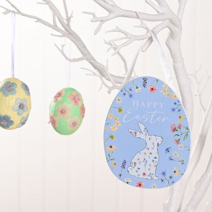 Decorative Easter eggs with floral patterns and a bunny design on a white branch background.