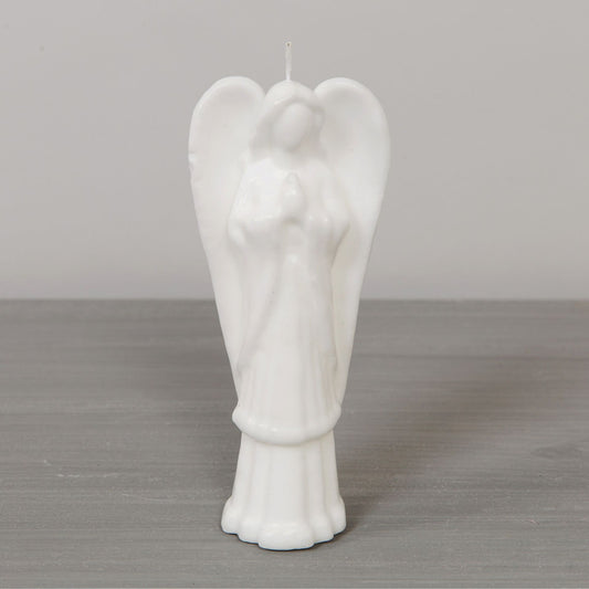 White angel-shaped candle on a gray surface with a neutral background