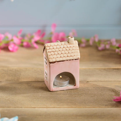 Pink ceramic miniature house ornament | Decorative cottage figurine with tan roof and floral detail in a garden setting | UK home or garden décor