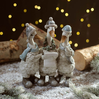 Christmas Carolling Goose Figure Trio | Resin decoration of three geese wearing knitted hats, scarves, and boots, holding a song sheet UK