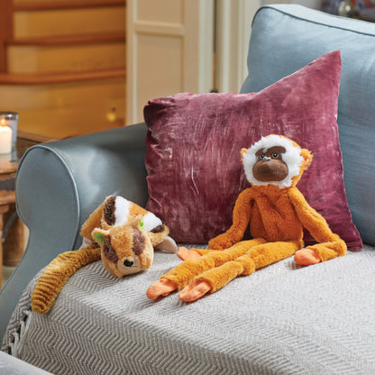 Two plush toys on a gray couch with a purple pillow in the background.