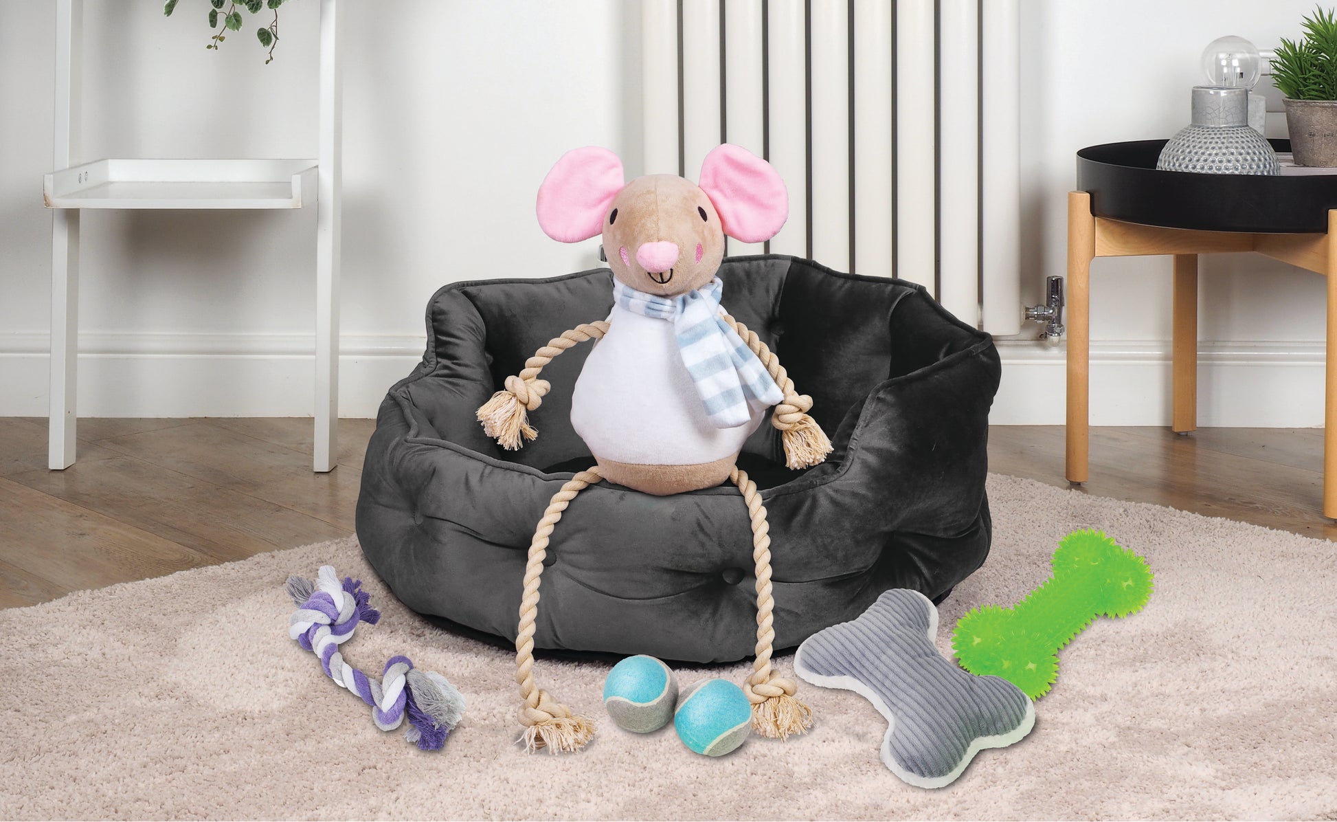 Dog toy shaped like a mouse with a chair, rope, and toys on a carpeted floor.