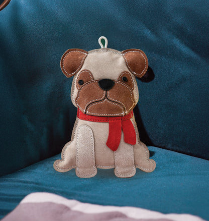 Stuffed dog toy with a red scarf on a blue cushion