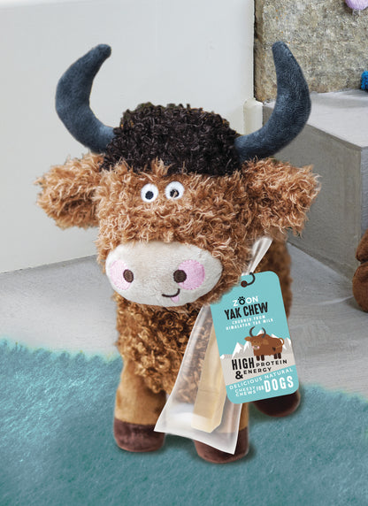 Plush toy yak with a tag labeled 'Yak Chew' on a light background